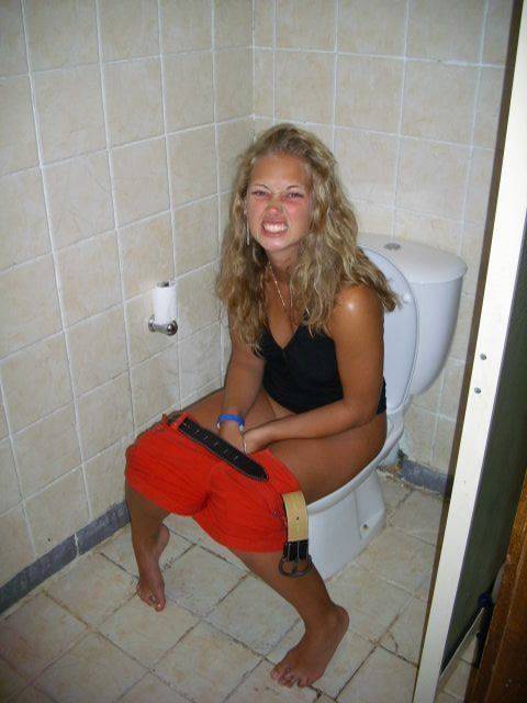 Naked woman peeing in toilet